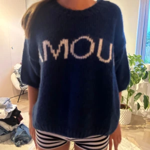 Mörkblå stickad tröja med Amour text  - Säljer en jättefin stickad kortärmad tröja från design by si💘helt oanvänd med lapp fortfarande kvar💘