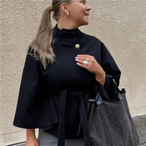 Missäy poncho  - Snygg svart kappa med omlottknäppning och bälte i midjan. Jackan har vida ärmar och en minimalistisk design som ger en cool och stilren look. Perfekt för dig som gillar oversized och trendiga siluetter.