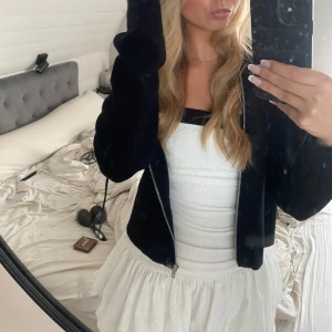 Vit och svart kort klänning från Zara - Supersöt kort klänning från Zara i vit med svarta breda axelband och kant upptill. Klänningen har en rynkad struktur och volangig kjol, perfekt för dig som gillar en feminin och trendig look. Sitter snyggt med figurnära passform och fyrkantig ringning.