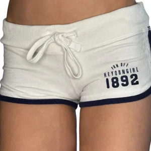 Vita shorts  - Superfräscha vita shorts med marinblå kant och tryck framtill. De har snörning i midjan. Inte så använda. Obs går ej ner i pris