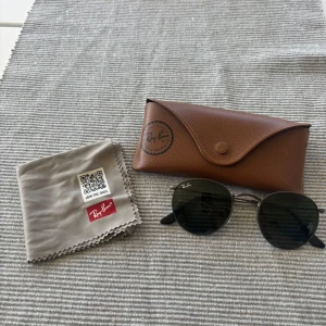 Ray-bans Förhandlingsbara - Snygga Ray-Ban solglasögon med runda svarta metallbågar och mörka glas. Kommer med originalbrunt fodral och putsduk. Nästan aldrig använda ligger bara o sammlar damm. Kom även med pris förslag!😁