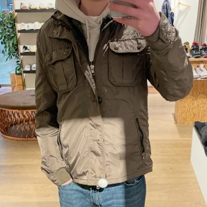 Moncler "Mate" field jacket - Säljer denna jätte fina moncler jacka i modellen mate, färgen är mörkgrön (ser ljusare och brunare ut på bilden). Jätte fint skick men saknar en knapp uppe vid halsen som absolut inte påverkar på något sätt då man aldrig har den helt knäppt. Storlek 3 som motsvarar ca S/M. Överlag jättefint skixk med mindre defekter.☺️såklart äkta och köpt på Second place i Malmö för ett rabatterat pris och har även kvittot. Kontakta vid bud/frågor.