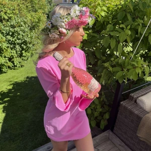 Rosa kortklänning med rosett i ryggen - Superfin rosa kortklänning med långa ärmar och en rosett i ryggen. Klänningen har öppen rygg och är figurnära med en enkel, stilren design. Endast använd en gång, perfekt för somriga dagar🩷
