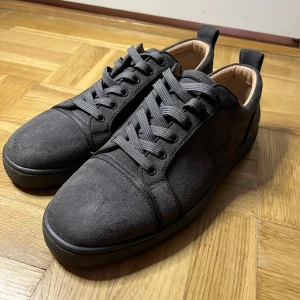 Christian Louboutin svarta mockasneakers - Helt nya har bara använt dem 2 gånger.Köpte för 6800 har inget kvitto Snygga svarta sneakers från Christian Louboutin i mocka med klassisk röd sula. Skorna har rund tå, platt sula och snörning. Perfekta för dig som vill ha en lyxig och stilren look med en ikonisk touch.