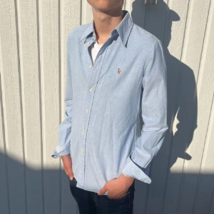 Ljusblå skjorta från Ralph Lauren - Snygg ljusblå skjorta från Ralph Lauren, toppskick inga märken eller liknande 10/10, perfekt färg nu till sommaren! Storlek M