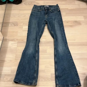 Lågmidjadd bootcut jeans i 32 - Snygga blå bootcut jeans från Gina Tricot i modellen perfect jeans med låg midja. Klassisk femficksdesign och lätt slitning framtill. Jeansen har en smalare passform och ger en retrovibe.