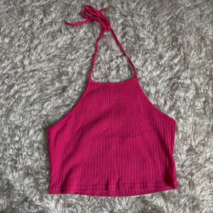 Ribbad rosa linnetopp  - Säljer en ribbad rosa linnetopp  i storlek M. Toppen har halterneck med knyt i nacken och är croppad. Perfekt för varma dagar och enkel att matcha med jeans eller kjol.