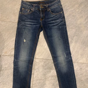 Blå jeans från Nudie Jeans - Riktigt snygga nudie jeans med feta slitningar! Som nya! De är i färgen blå och är i storlek 27/33 men sitter mer som 28/33! Bara att höra av sig vid funderingar/frågor!👍