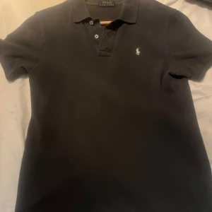 Mörkgrå pikétröja från Ralph Lauren - Snygg mörkgrå pikétröja från Ralph Lauren. Storlek S passar alla från 160-173cm. Vid snabb å smidig affär kan priset diskuteras!