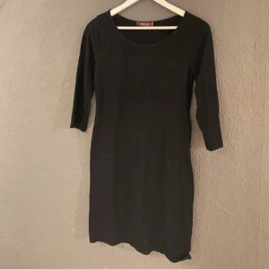 Svart klänning  - Snygg svart klänning med trekvartsärm. Perfekt för en stilren look. Klänningen har en enkel design som gör den lätt att matcha med olika accessoarer.
