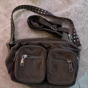 Brungrå axelväska med nitar - Noella väska i en brungrå färg, använd en del men ändå bra skick!