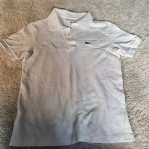  piké från Lacoste - Vit lacost piké. Kontakta mig gärna om du har frågor eller är intresserad!