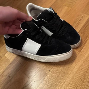 Valentino flycrews  - Snygga svarta flycrews med vita detaljer och nitar på hälen. Skorna har en klassisk design. Sulorna är inte med samt boxen där av priset