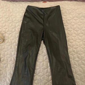 Svarta skinnbyxor från Pieces - Snygga svarta skinnbyxor från Pieces i storlek XS. Byxorna har en bootcut-stil som ger en trendig look. Inte äkta skin. Saknar en knapp men har inte påverkat funktionen för mig