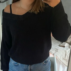 Svart stickad tröja från Gina Tricot - Säljer en svart stickad tröja från Gina Tricot. Tröjan har en v-ringad design och långa ärmar. Perfekt för en stilren och bekväm look. Passar bra till jeans eller kjol.