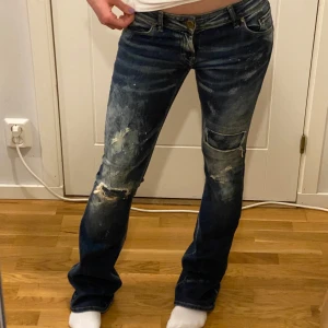 Supercoola jeans - Lågmidjade bootcut jeans med supercool slitage-look på framsidan, midjemått ca 39cm & innerbenslängd ca 88cm