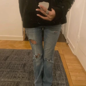 Lågmidjade jeans  - Snygga blå jeans med slitningar på knäna och låren. De har en bootcut-stil som ger en avslappnad look. Perfekta för en trendig och casual stil. De är i strl 152 och ja är 154 cm. Men passar xxs 