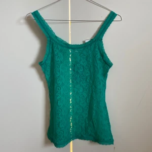 Grön spetslinne från Anthropologie - Säljer en jättefin genomskinlig grön spetslinne.  Den är helt ny och har etiketten kvar. Jag köpte den för 400 kr