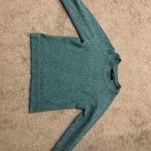 Grön stickad tröja från Vero Moda - Säljer en mysig grön stickad tröja från Vero Moda. Tröjan har en enkel design med långa ärmar och rund halsringning. Perfekt för kyligare dagar. Storlek S men stretchigt material så passar även folk med storlek M! Kontakta mig för fler bilder!
