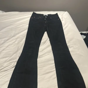 Svarta bootcut jeans - Snygga svarta bootcut jeans med låg midja och klassisk femficksdesign. Perfekta för en stilren look. De har en dragkedja och knapp framtill. Skriv privat för mer info