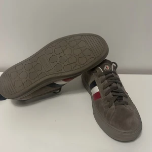  Moncler skor i storlek 40,5 - Säljer ett par gråa moncler skor i storlek 40,5. Säljer skorna pågrund av att jag inte använder de längre. Det finns inga skador på skorna, skick 8/10