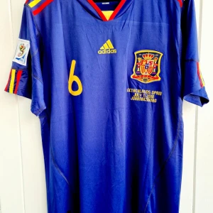 Andres Iniesta - Spanien VM-final 2010 - Klassisk matchtröja  - Säljer en klassisk fotbollströja, Andres Iniestas matchtröja från VM-finalen 2010 när avgjorde så att hans Spanien vann över Holland och blev världsmästare. Tröjan är en remake i nyskick och har finalen och datumet inskrivet på bröstet (samma text som Iniesta hade på sin tröja under finalen).   Large, normal i storleken.