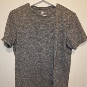 Grå t-shirt från H&M  - T-shirten är kortärmad och tillverkad i ett mjukt bomullsmaterial med stretch för extra komfort. Perfekt för träningen eller en avslappnad