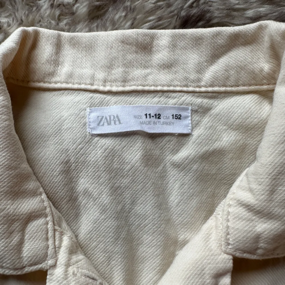 Säljer en söt beige blus från Zara med korta puffärmar och knytning framtill. Blusen har knappar längs framsidan. Paidat.