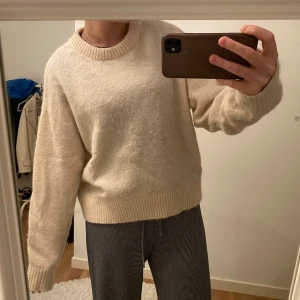 Beige stickad tröja - Mysig beige stickad tröja från Alpaca Blend kollektionen från BikBok med rund halsringning och långa ärmar. Perfekt för kyligare dagar och enkel att matcha med olika outfits. Nypris är 499 och jag säljer för 250kr