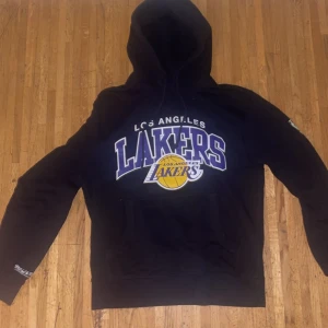 LA Lakers hoodie - Svart LA Lakers hoodie från Mitchell & Ness. Använt några gånger 