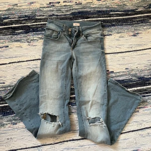 Nelly Jeans - Nelly jeans i storlek XXS/32. Dock är de väldigt stretchiga och passar absolut en XS/34. Nästan nyskick. Det enda som är att hålen på knäna är lite slitna. Lågmidjade och bootcut. Pris är diskuterbart och hör av dig om det är något!