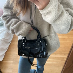 Svart handväska med silverdetaljer - Svart handväska med silver detaljer, citybag-liknande!! Kommer med en axelrem så kan användas som både axelremsväska och handväska. 💛 kan gå ner MYCKET i pris vid snabb affär! 