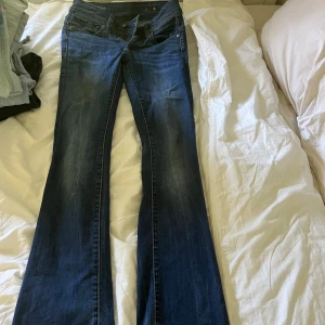 Bootcut lågmodjade jeans från g-star - Mörkblå jeans med tvätt fram. Lite slitna längst ner pga för långa