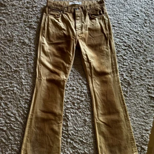 Beige bootcut byxor från Séfr - Snygga beige bootcut-byxor från Séfr, modell Rider Cut W. Tillverkade i 100% bomull med klassisk femficksdesign och normal passform. Byxorna har en cool, lite tvättad look och är perfekta för dig som gillar en avslappnad men stilren vibe.