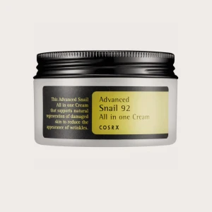 COSRX Advanced Snail 92 Cream - En återfuktande ansiktskräm med snigelsekret från COSRX. Kommer i en rund, vit plastburk med svart lock och gul etikett. Perfekt för dig som vill boosta hudens lyster och elasticitet med koreansk hudvård. Helt ny och aldrig använd