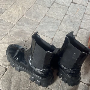 Svarta chunky chelsea boots - Säljer ett par svarta chelsea boots med chunky sula och glansig finish. Skorna är i strl 41 och från Zalando.