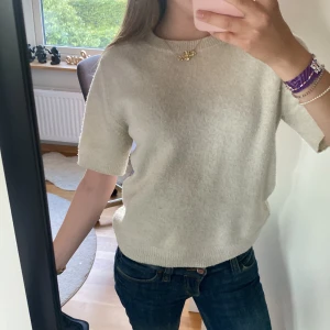 Beige stickad kortärmad tröja  - Supermjuk och enkel beige stickad tröja från H&M med korta ärmar. Perfekt till jeans eller kjol för en chill och stilren look. Ribbad kant vid ärmslut och nederkant ger en snygg finish. 💞😊