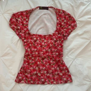 Blommig topp  - Supersöt topp med blommigt mönster i rosa, rött och vitt. Den första bilden (jag tror) är samma eller liknande som den andra bilden jag säljer, står ingen storlek eller vart den är ifrån men skulle gissa på att den skulle sitta bra på nån som är s/m jag har även sytt in den vilket man kan enkelt sprätta upp! 🌻