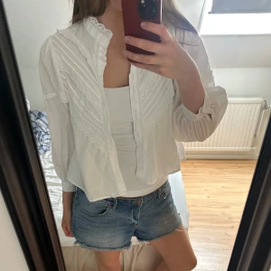 Vit blus med spets och knappar - Supersöt vit blus med spetsdetaljer. 