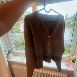 Söt kofta med knappar - Mysig brun kofta med snygga knappar framtill. Långärmad och i en loose passform, perfekt att slänga på sig när det är kyligt. Materialet känns mjukt och stickat, vilket gör den extra skön att bära🥰💕Koftan är i storlek L men passar mig som är Xs/S💕