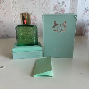 Parfums de Marly Greenley EdP 125ml - Greenley från Parfums de Marly är en lyxig Eau de Parfum i en stilren grön glasflaska med guldfärgat lock. Flaskan har ett elegant reliefmönster med två hästar och sköld. Kommer med originalkartong och informationshäfte i matchande mintgrön färg.