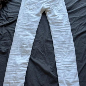 Vita jeans från Tiger of Sweden - Snygga vita jeans från Tiger of Sweden med klassisk femficksdesign och raka ben. Jeansen har normal passform och är tillverkade i bomull med en liten stretch för extra komfort. Perfekta för dig som vill ha en clean och fräsch look.