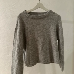 Grå stickad tröja med rund hals - Mysig grå stickad tröja med rundad halsringning 