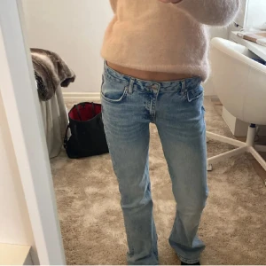 Ljusblå Gina tricot jeans - Säljer ett par ljusblåa lågmidjade jeans från Gina tricot med låg midja och bootcut-snitt. Jeansen har fem fickor, knappgylf och är tillverkade i slitstarkt bomullsjeans. Perfekta för dig som gillar en avslappnad och tidlös look.