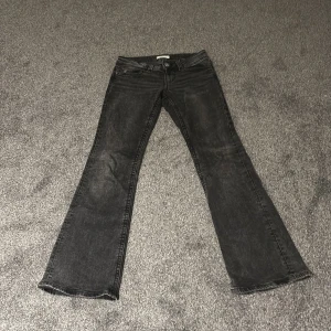 Svarta bootcut jeans från Perfect Jeans - Snygga svarta bootcut jeans från Perfect Jeans i storlek 36. Jeansen har klassisk femficksdesign, silverfärgade knappar och en lätt tvättad look. Perfekt för dig som gillar en lite utsvängd passform och vill ha ett par jeans som sticker ut.