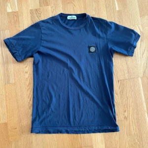Stone island T-shirt  - Stone island T-shirt i bra skick. Storlek S, mörkblå,  2 små lagade hål vid märket på framsidan (bild 2) men de syns knappt, annars fint skick. Bara att höra av sig vid frågor eller funderingar.