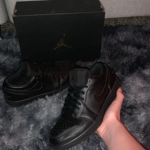 Nike Air Jordan 1 Low Triple Black - Tja säljer ett par Jordan low 1 som jah inte använder längre. Skicket på dom är 8/10 och absolut inget fel på dom förutom att dom är använda några gånger då. Bara skicka ett pris förslag!✌🏽