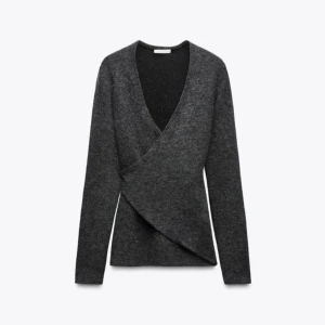 Zara Mörkgrå omlottkofta med v-ringning - Snygg mörkgrå omlottkofta med v-ringad hals och långa ärmar. Koftan har en stilren och modern look med omlott-detalj framtill. Perfekt att slänga på sig över en topp för en chill men ändå uppklädd vibe. Från Zara lapparna fortfarande kvar!❤️