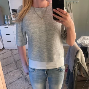 Grå strickad tröja - Kortärmad stickad tröja, stor i storleken. Endast använd fåtal gånger 