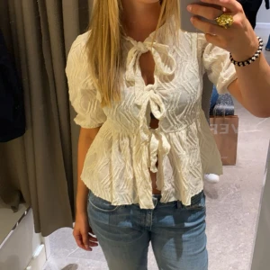 Krämvit blus  - Supersöt krämvit blus i storlek S från Gina Tricot med strukturmönster, knyts framtill. Kommer tyvärr inte till användning och är knappt använd.
